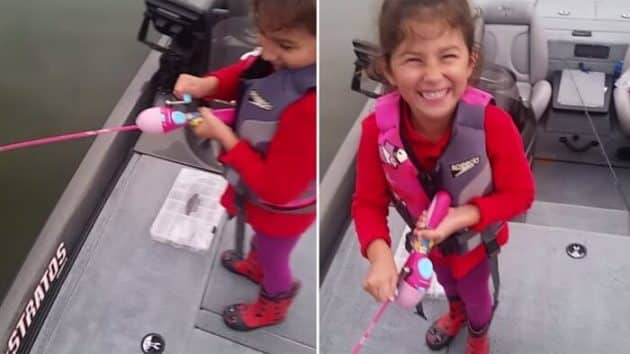 Une fillette attrape un poisson avec sa canne à pêche Barbie canne à pêche Barbie, bar, poisson